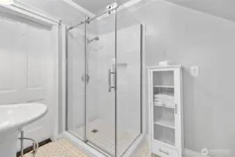 Large tiled shower; door on left is to the hallway.
