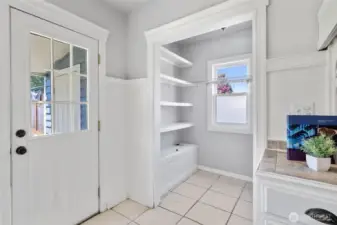 Lots of extra storage shelves in the pantry. Door leading to the yard; door seen through the window is to the laundry room.