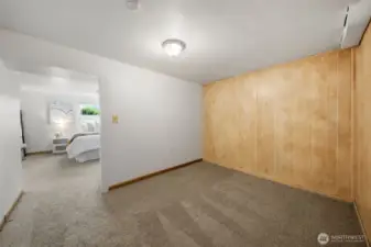 This bonus area just off the lower-level bedroom offers added flexibility for a sitting room, dressing area, or additional storage. Wood paneling and soft carpet make it a natural extension of the adjacent living space.