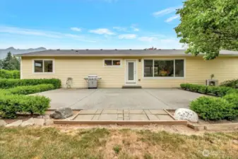 Large patio that looks out at the large back yard and Whitehorse Mountain