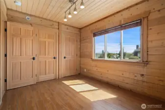 Main level bedroom - shown here without the virtual staging in place. Generous closet space and nice outlook.