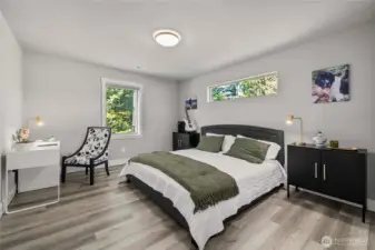 Upstairs Lg bedroom - this is a kingsize bed! With a view of the trail head and trees