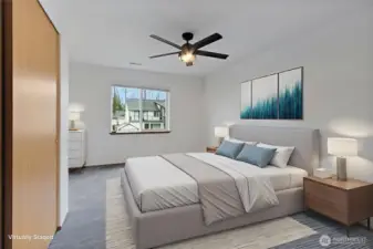 Primary bedroom featuring ceiling fan and window, with bathroom access; image virtually staged.