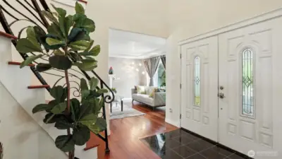 Grand entry with sweeping staircase and soaring ceiling.