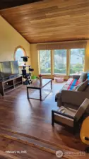 Step down to your family room and enjoy.  Note the warm touch of the beams and wood ceilings and floors.