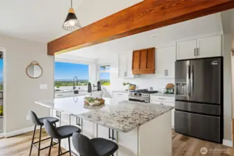 Sleek and functional kitchen featuring a spacious island and brand new stainless steel appliances.