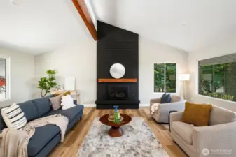 Cozy up by the gas fireplace in this stunning living room, framed by oversized windows that flood the space with natural light and showcase tranquil outdoor views.