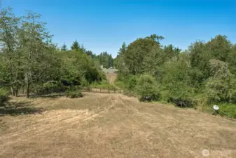 This view captures what makes the property truly special. From the edge of the deck, a clear path leads across the lawn to the edge of the deeded property, then onto an easement that takes you to 235 feet of beach shoreline on Henderson Inlet. Whether it’s morning coffee or a sunset stroll, this is the kind of everyday access that rarely comes with this much space and privacy.