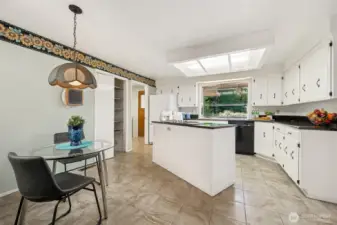 This kitchen keeps it fresh with crisp white cabinetry, neutral tile flooring, and a layout that actually works. The breakfast nook adds charm without wasting space, and the vintage tulip light fixture is the kind of detail that makes the room feel personal, not cookie-cutter.