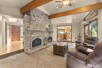 Vaulted ceilings & exposed wood beams perfectly highlight your beautiful brick fireplace. A Russian fireplace keeps you warm & cozy during the cold & rainy months as it radiates heat throughout.