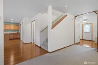 This view of the entry, staircase, and kitchen highlights the new wood trim that is seen throughout the home--adding quality style and character to every door and corner.