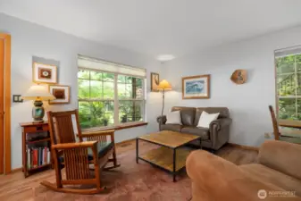 The living room is spacious and light and bright, as it has large windows that look out to the gorgeous landscaping.