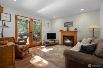 The family room is also light and bright and has a lovely gas fireplace with a wood surround and mantle. The French doors open onto an expansive deck that over looks the forested parcels that surround the home.