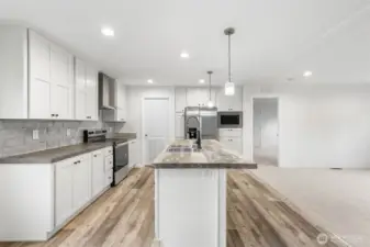 Beautiful stainless steel appliances, canned lighting and pendant light over the island.