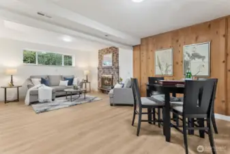 We love this super functional lower level rec-room! So warm, with the brick fireplace, new LVP flooring and wood paneling.