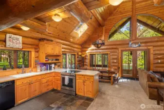 Welcoming entry opens to a warm, open-concept great room and kitchen, showcasing rich wood finishes, vaulted ceilings, and an inviting layout designed for gathering.