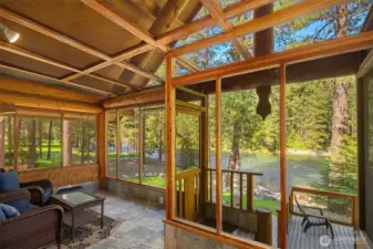 Screened porch with soaring ceiling, slate flooring, and front-row views of the Wenatchee River—an inviting space to relax and take in the sounds of the water.