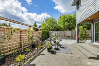 Extended patio with trellis and completely fenced back yard.