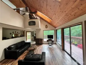 bright and sunny living space with enormous windows and vaulted ceilings w/ skylights