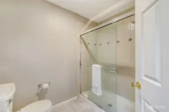 Glass-enclosed walk-in shower with classic tile design, complementing the spa-like ambiance of the en-suite bath.