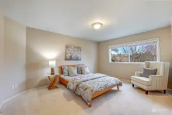 Another inviting bedroom with neutral tones and a large window, offering a comfortable and versatile space.