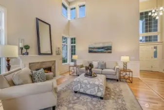 Enjoy the elegance of this open living space, where the grand staircase serves as a stunning backdrop. The high ceilings and tall windows enhance the sense of space, making the home feel both luxurious and inviting.