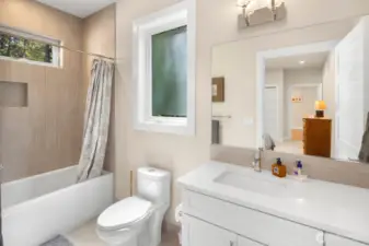 En-suite bath features a deep soaking tub and lovely tilework.