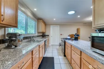 Kitchen with large window with view of side yard. Stainless steal appliances. Granite countertops