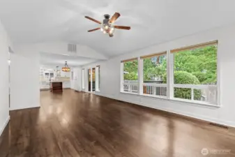 Dining/living area open to kitchen with backyard views.