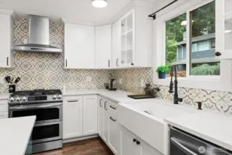 Stylish kitchen featuring farmhouse sink, stainless appliances, and designer tile backsplash.