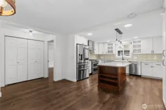 Modern kitchen with white cabinetry, quartz counters, and island with seating and storage.