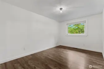 Second bedroom with window overlooking front landscaping.