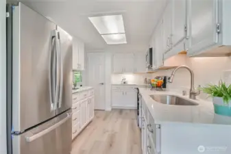 Beautiful kitchen remodel features granite counters, fresh resurfaced white cabinets, new undermount sink faucet, new SS appliances.