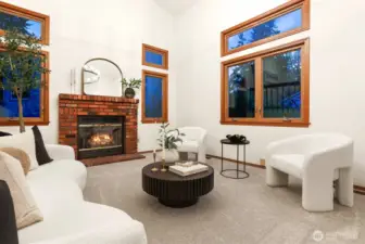 Living room with gas burning brick fireplace flanked by wood wrapped side lights.
