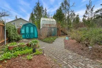 Private rear yard has garden shed, raised green house, paver walk ways around the native PNW gardens.