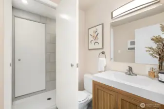 Functional guest bath offers walk in shower that is accessible from primary bathroom.