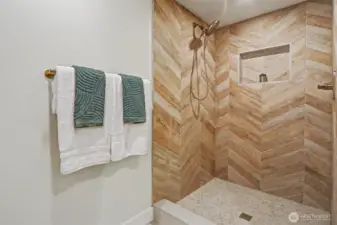 Primary walk in shower with designer tile