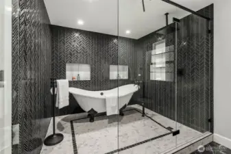 Beautiful clawfoot tub in a shower with custom glass doors