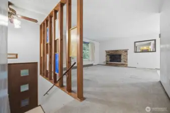 Upstairs there is a spacious living room which is open to the dining area. There is a wood burning fireplace.