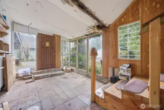 Looking at the back entry which was enclosed and possibly not permitted.