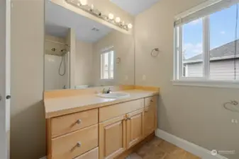 Main bathroom with large mirror, great storage and window.