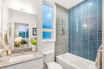 En suite bathroom to primary bedroom. Hansgrohe plumbing fixtures in shower, with separated controls to turn on before stepping in