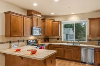 The complete kitchen has an eat bar, tiled counters and stainless appliances.
