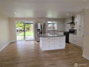 Updated & modernized kitchen with stone counter tops, large island, gas appliances, walk in pantry & pot filling faucet above the cookstove & new LVP flooring. #11823 150th St Ct E, Puyallup, WA 98374