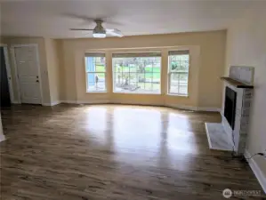 Open floor plan living area with brand new gas fireplace & LVP flooring. #11823 150th St Ct E, Puyallup, WA 98374