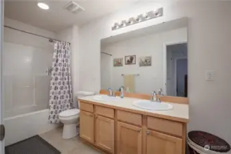 Full bath upstairs with dual sinks and a large linen closet