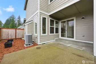 Fully fenced side yard with semi-covered patio.