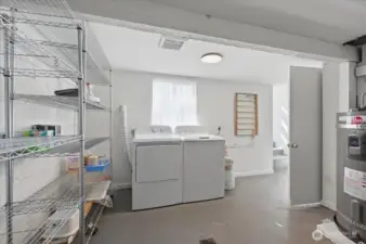 Large laundry area (washer & dryer & shelving racks stay.  This room also houses the gas furnace installed 2017 & 50 gallon electric hot water heater with expansion tank (brand new - installed 3/2026.  This room is accessible by back door making a potential shared laundry room easy, if desired