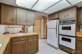 Second view of the kitchen which has a double oven.  The door in the middle of the photo is a spacious step-in pantry.