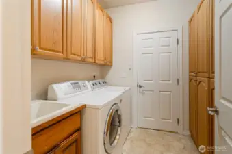 Utility room has added storage, deep sink.  Washer and dryer stay.  Door leads to garage.